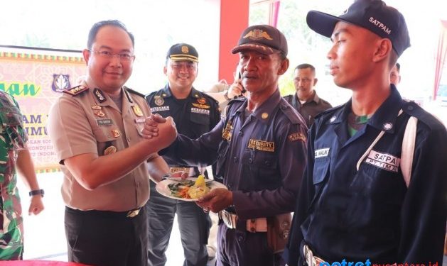 Kapolres Karimun Yos Guntur Yudi FS saat memberikan kue tumpeng kepada salah satu satpam
