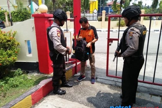 Anggota kepolisian melakukan pemeriksaan barang bawaan orang yang memasuki wilayah Polsek Karimun