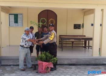 Anggota Polsek Tebing, T Siregar foto bersama jemaat Gereja sebelum melakukan penanaman pohon
