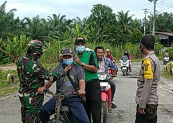 Cegah Penyebaran Covid-19, Petugas Posko PPKM Desa Orika Bagi-Bagi Masker