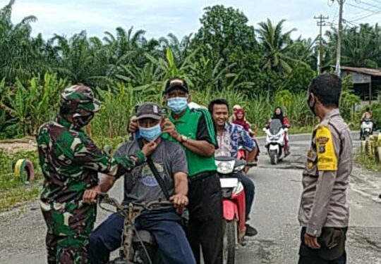 Cegah Penyebaran Covid-19, Petugas Posko PPKM Desa Orika Bagi-Bagi Masker