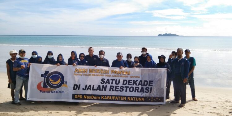 Sambut HUT Partai Nasdem Puluhan Kader Gotong Royong Bersihkan Objek Wisata Pantai Tanjung