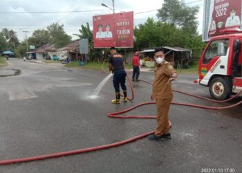 Wabup Lingga Bersama Damkar Bersihkan Jalan Berpasir di Kota Dabo