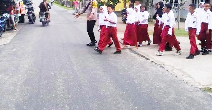 Strong Point, Bhabinkamtibmas Polsek Dabo Singkep Bantu Anak Sekolah Nyeberang Jalan